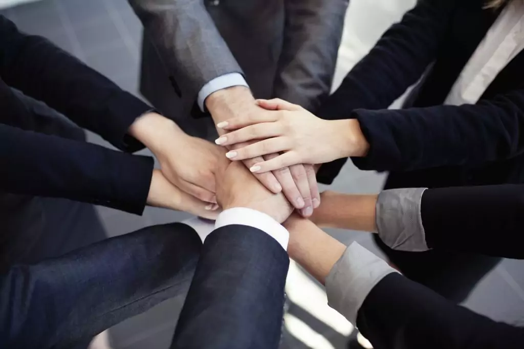 Group of business people joining hands.