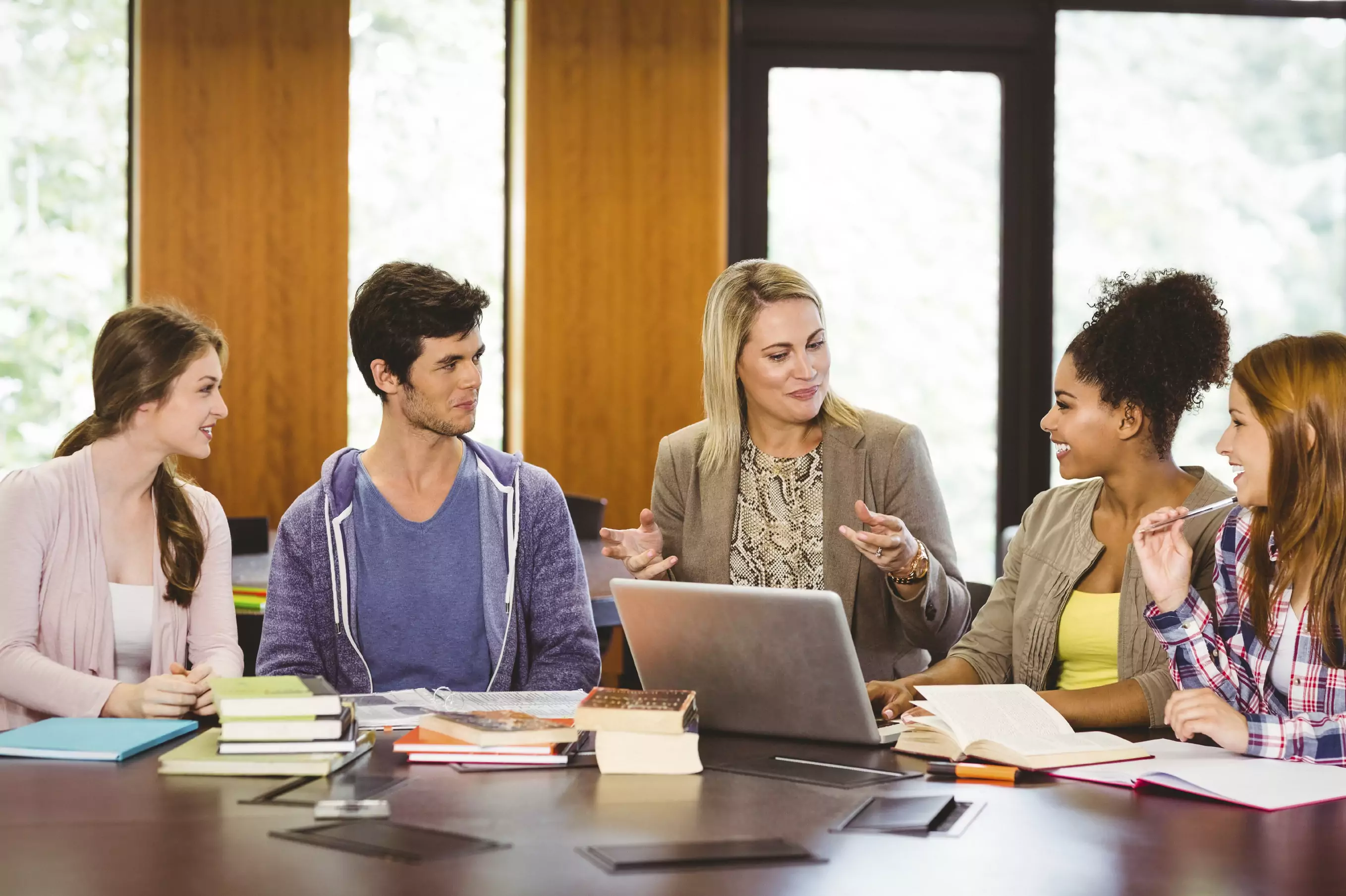 Smiling-female-with-students-and-teacher-in-library